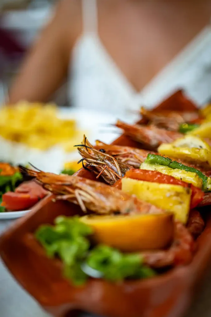 Plat portugais coloré avec crevettes grillées, légumes frais et tranches d'ananas