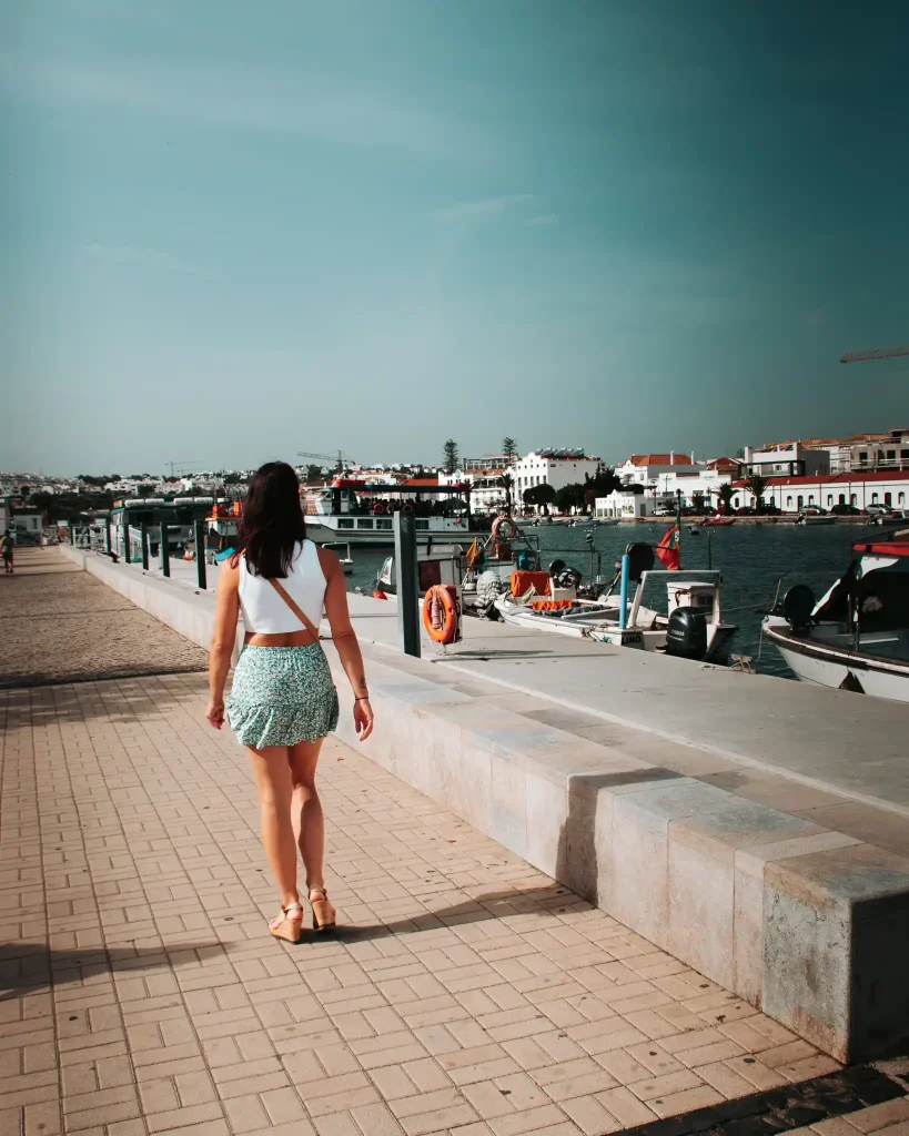 Caroline marchant le long du port de Tavira, Algarve, Portugal, par une journée ensoleillée.