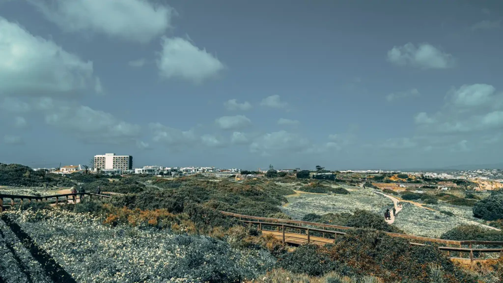 Coastal landscape of Lagos, Portugal, with views of the vegetation and cloudy sky, peaceful and natural atmosphere.