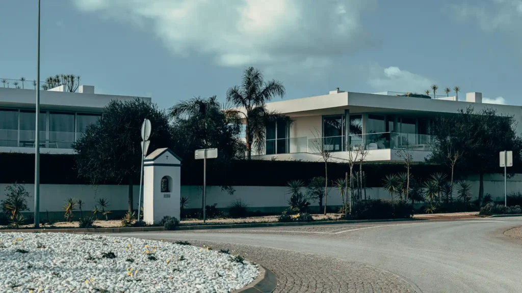 Modern building surrounded by vegetation in Lagos, Portugal, under a partly cloudy sky.
