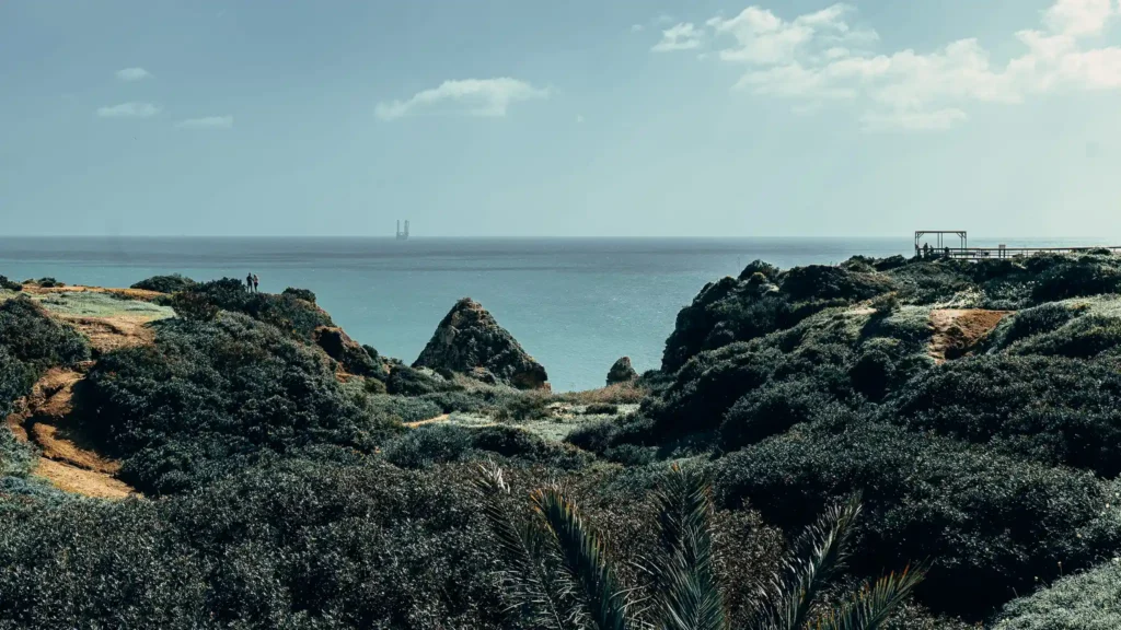 Ponte da Piedade in Lagos, Portugal, rocky cliffs overlooking the ocean under a partly cloudy sky.