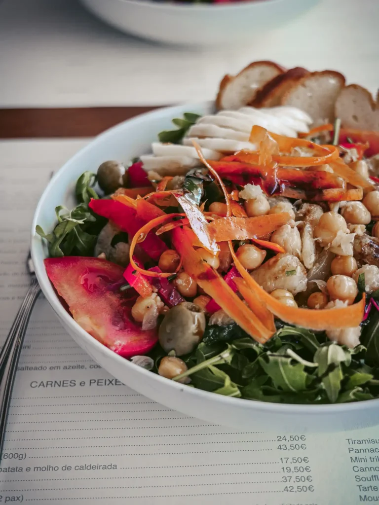 Salade colorée avec pois chiches, morue et légumes frais au restaurant Madrigal à Aveiro, Portugal.
