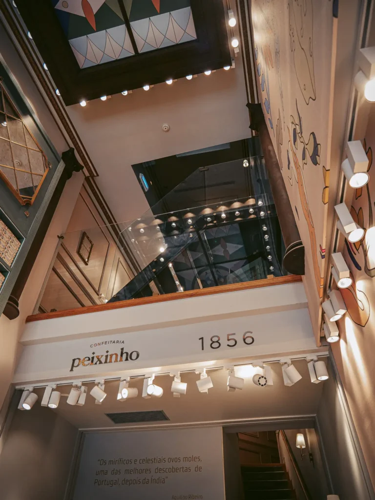 Interior of Confeitaria Peixinho in Aveiro, Portugal, warm lighting and modern decorations.