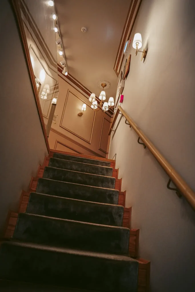 Well-lit interior staircase of Confeitaria Peixinho in Aveiro, warm and elegant ambiance.