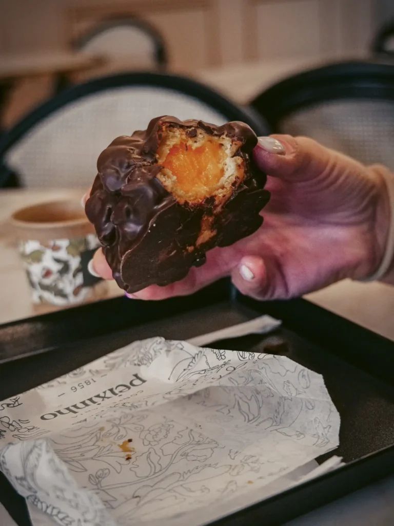 Hand holding a chocolate cake at Confeitaria Peixinho, Aveiro, Portugal