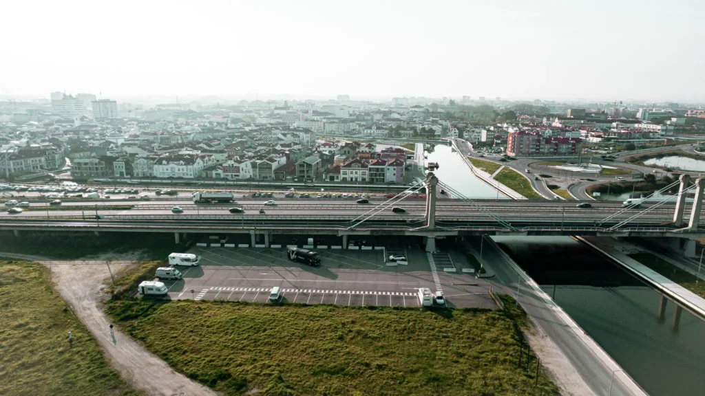 Aerial view of the Ria de Aveiro bridge, Portugal, with traffic and urban panorama in the background.