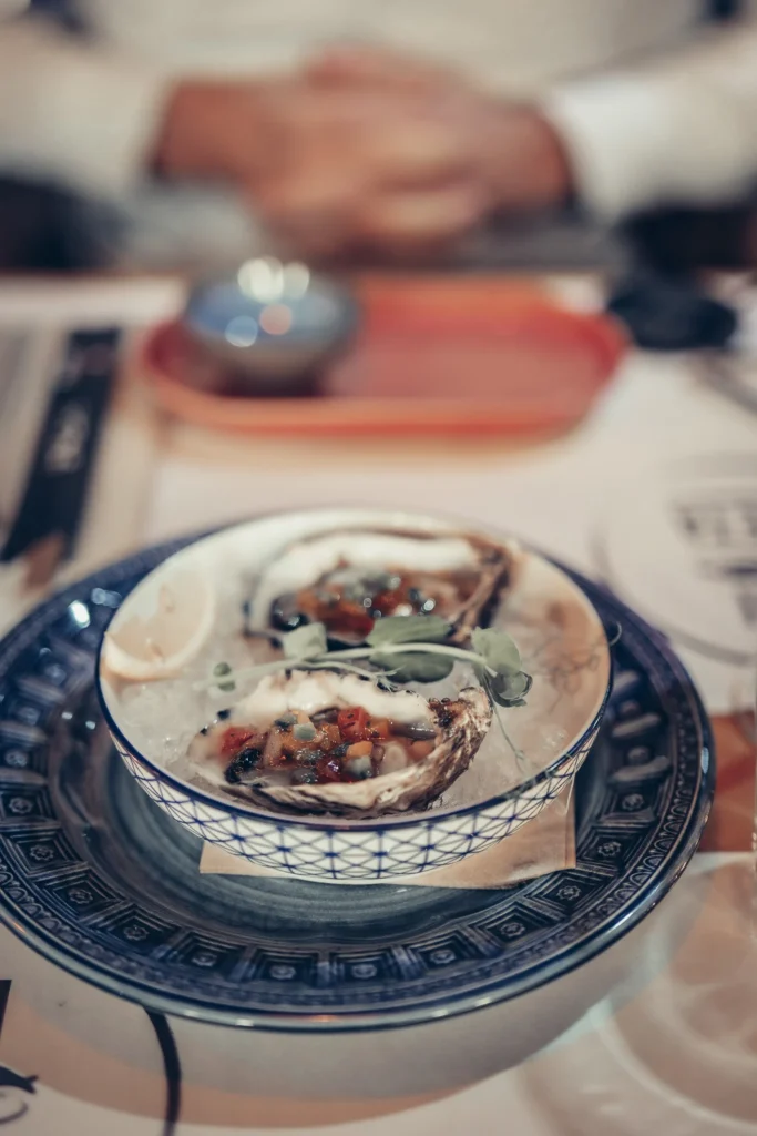 Oysters served on a blue patterned plate at Sushi na Gaveta, Tavira, Algarve, Portugal.