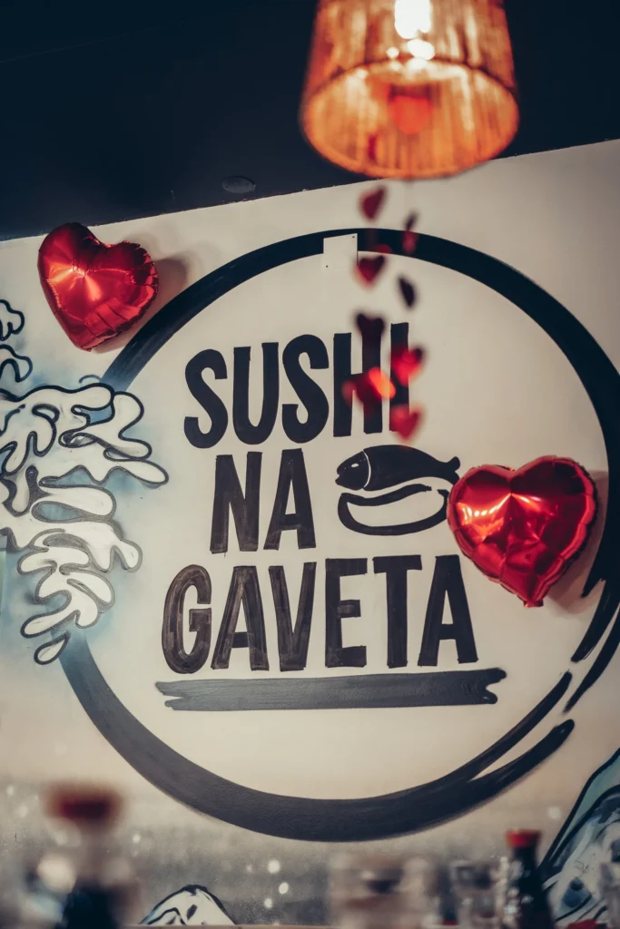 Logo of the restaurant Sushi na Gaveta in Tavira, decorated with red hearts  
---  
Glass of sparkling wine on a table decorated with red petals at the restaurant Sushi na Gaveta  
---  
Xavier enjoying a glass of wine in a romantic restaurant atmosphere with heart-shaped balloons.  
---  
Garnished oysters served at the restaurant Sushi na Gaveta in Tavira  
---  
Two shrimp verrines on slate at the restaurant Sushi na Gaveta  
---  
Chocolate dessert glasses with marshmallows at the restaurant Sushi na Gaveta.  
---  
Caroline tasting a dish at the restaurant Sushi na Gaveta, Tavira  
---  
Platter of assorted sushi at the restaurant Sushi na Gaveta, warm and friendly atmosphere in Tavira.  
---  
Assortment of colorful sushi at the restaurant Sushi na Gaveta in Tavira.  
---  
Sushi on a red plate with soy sauce, warm atmosphere at the restaurant "Sushi na Gaveta" in Tavira.  
---  
Artistic sushi dish in the shape of a swan at the restaurant Sushi na Gaveta, Tavira.  
---  
Gourmet dessert with heart-shaped cookie, cream, and red fruits, cozy atmosphere at the restaurant Sushi na Gaveta, Tavira.