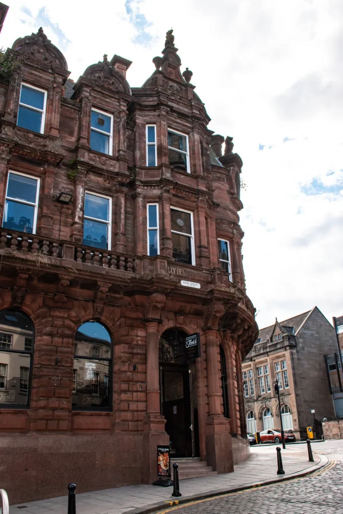 Facade of a historic building in red sandstone in Stirling with mullioned windows