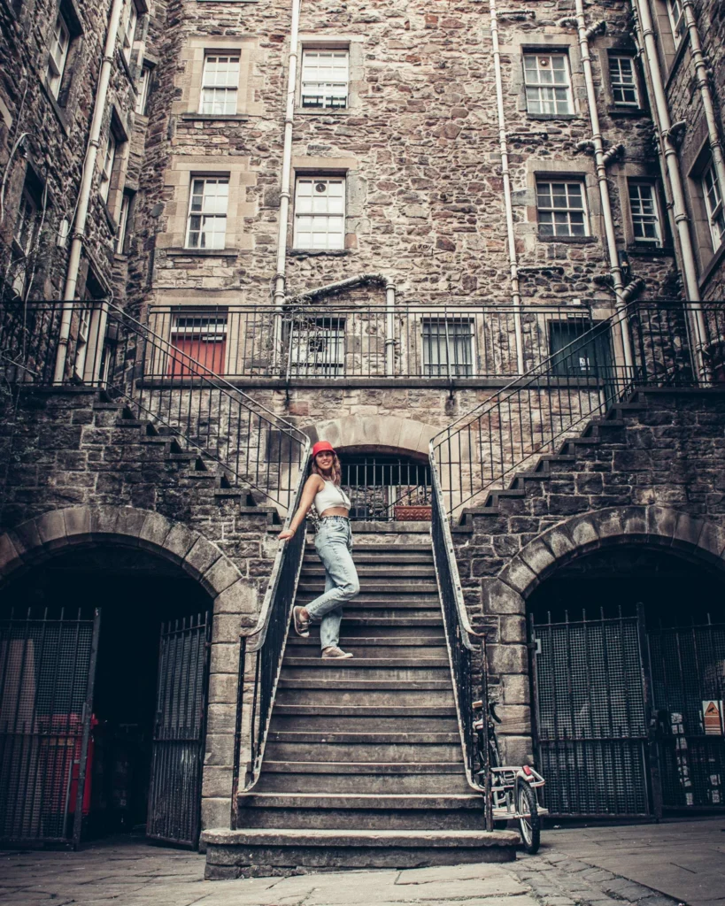 Caroline poses on a stone staircase in front of a typical Edinburgh facade.