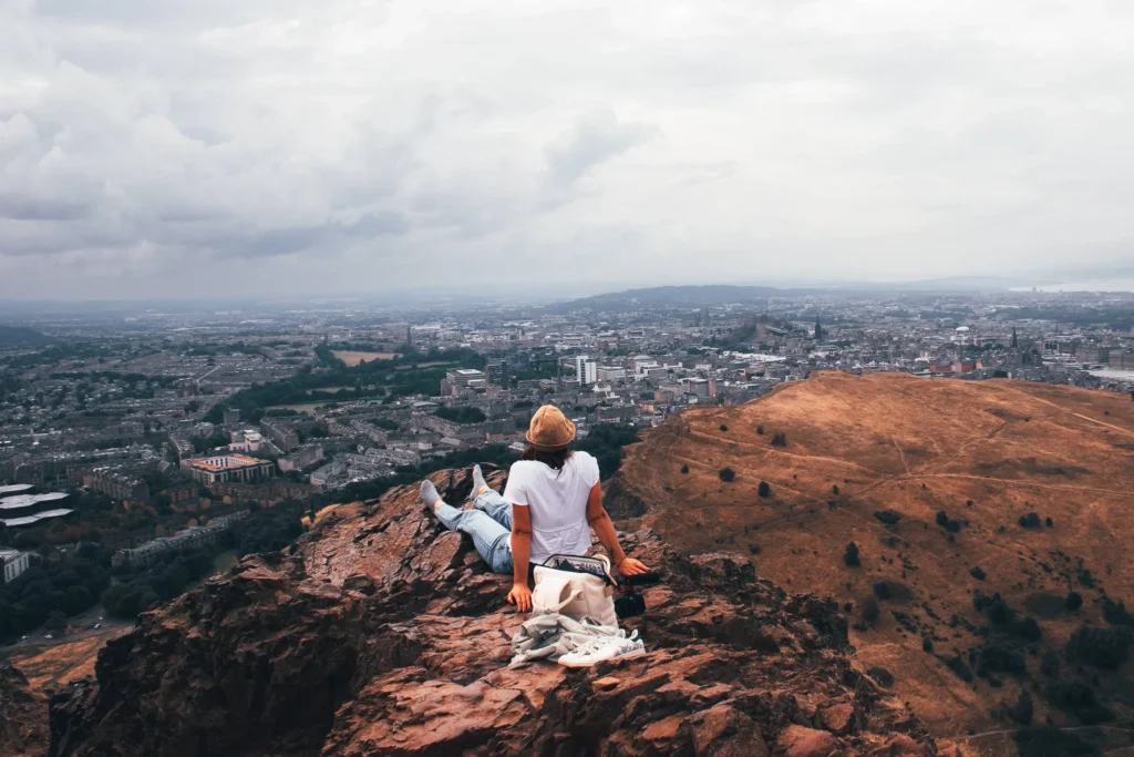 Caroline sitting at the top of Arthur's Seat overlooking Edinburgh