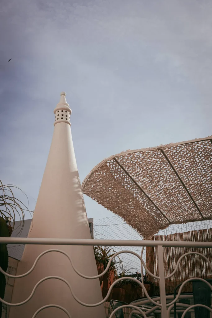 Traditional white fireplace from the Algarve and wicker pergola in an outdoor courtyard, under a slightly overcast sky in Fuseta.