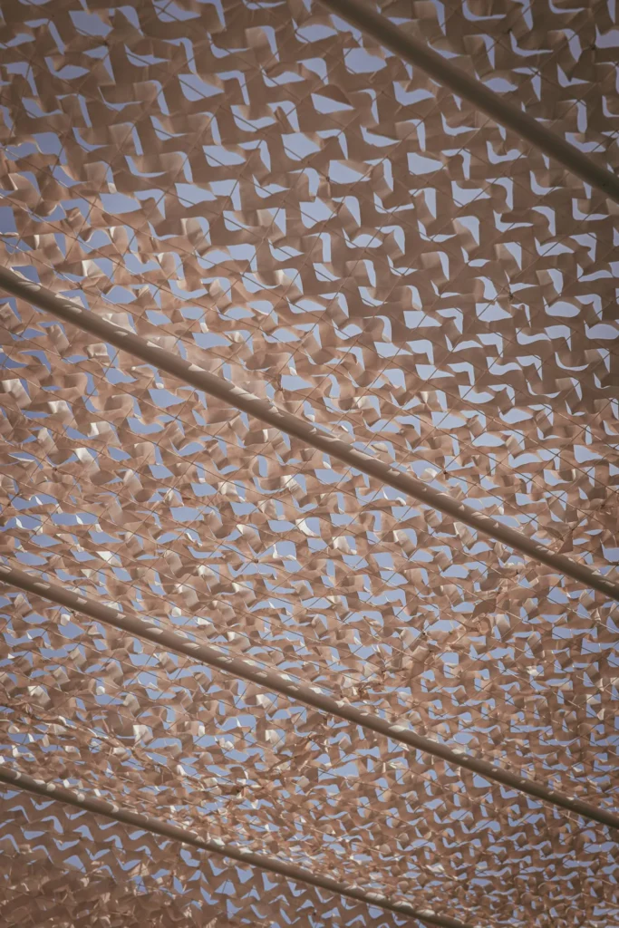 View from below of a perforated shade cloth stretched under the sky, probably installed during the Casita Erika shoot in Fuseta, Algarve.