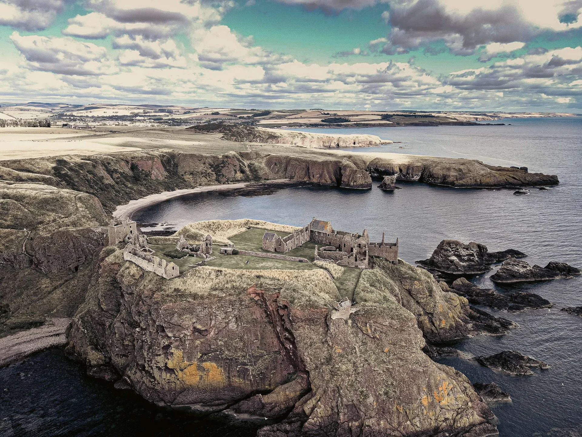 Aerial view of the ruined Dunnottar Castle perched on a cliff overlooking the North Sea in Scotland