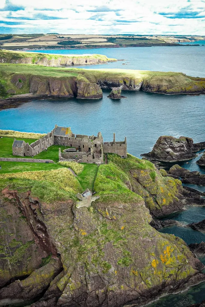 Aerial view of the ruined Dunnottar Castle perched on a cliff overlooking the sea