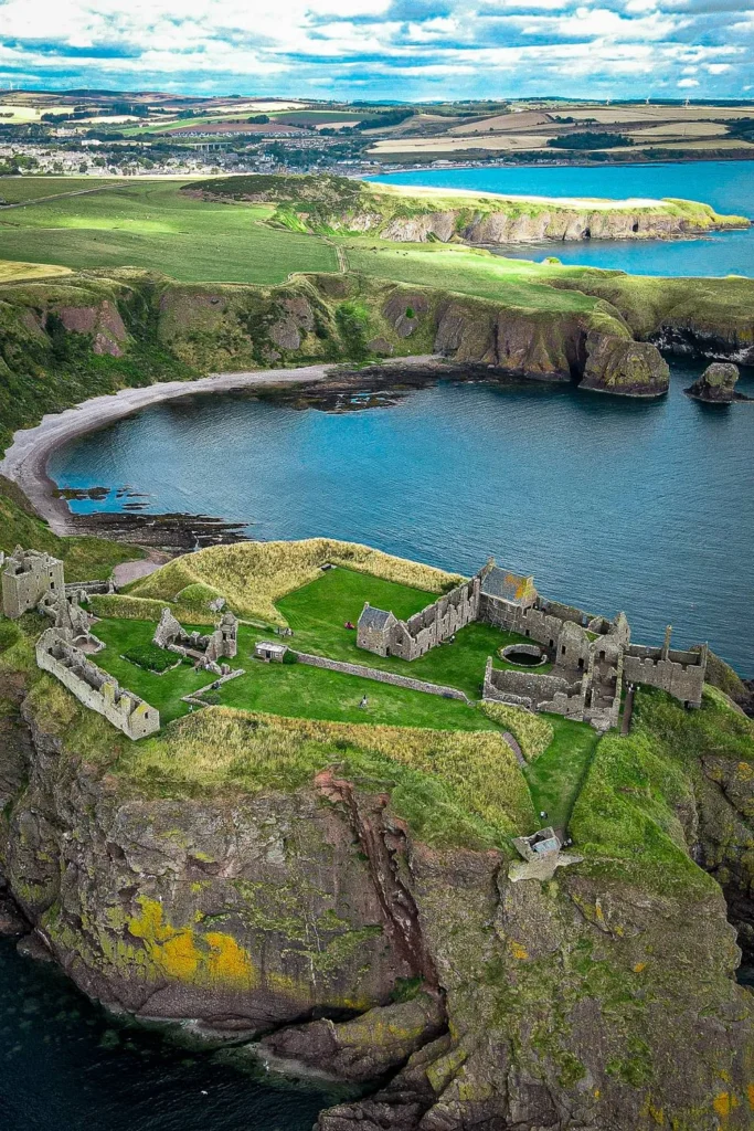 Aerial view of Dunnottar Castle perched on a cliff overlooking the sea
