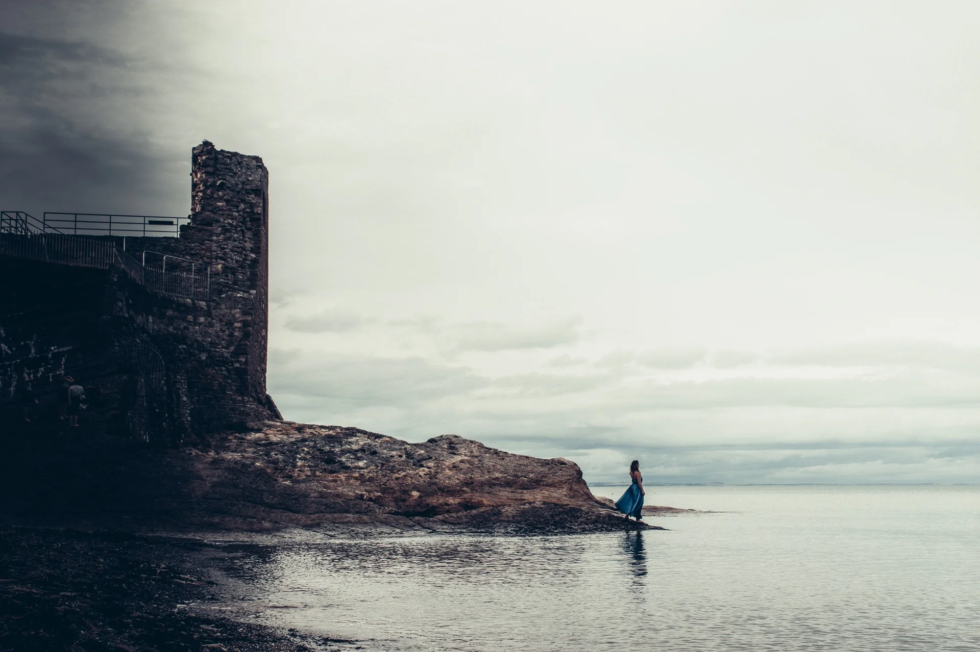 Rocky coast at St Andrews with an old stone tower and a small lawn