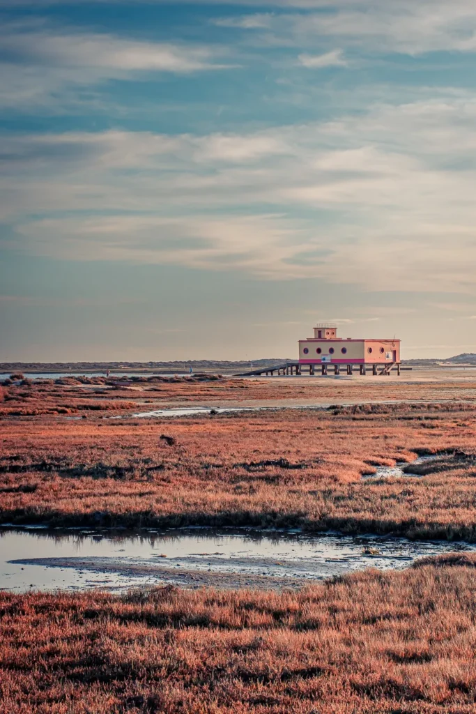 Bâtiment sur pilotis isolé au milieu des marais de Fuseta, sous un ciel partiellement nuageux en Algarve en novembre.