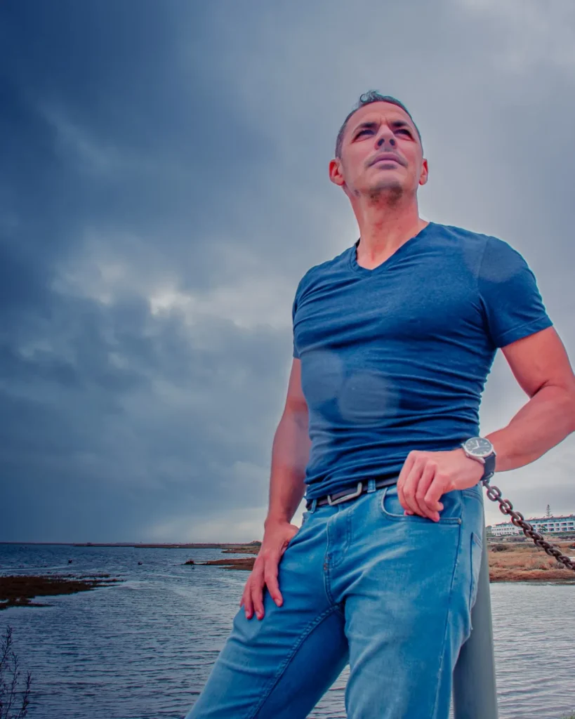 Xavier pose en bord de lagune sous un ciel nuageux à Fuseta, dans l'Algarve, le 18 novembre 2022.
