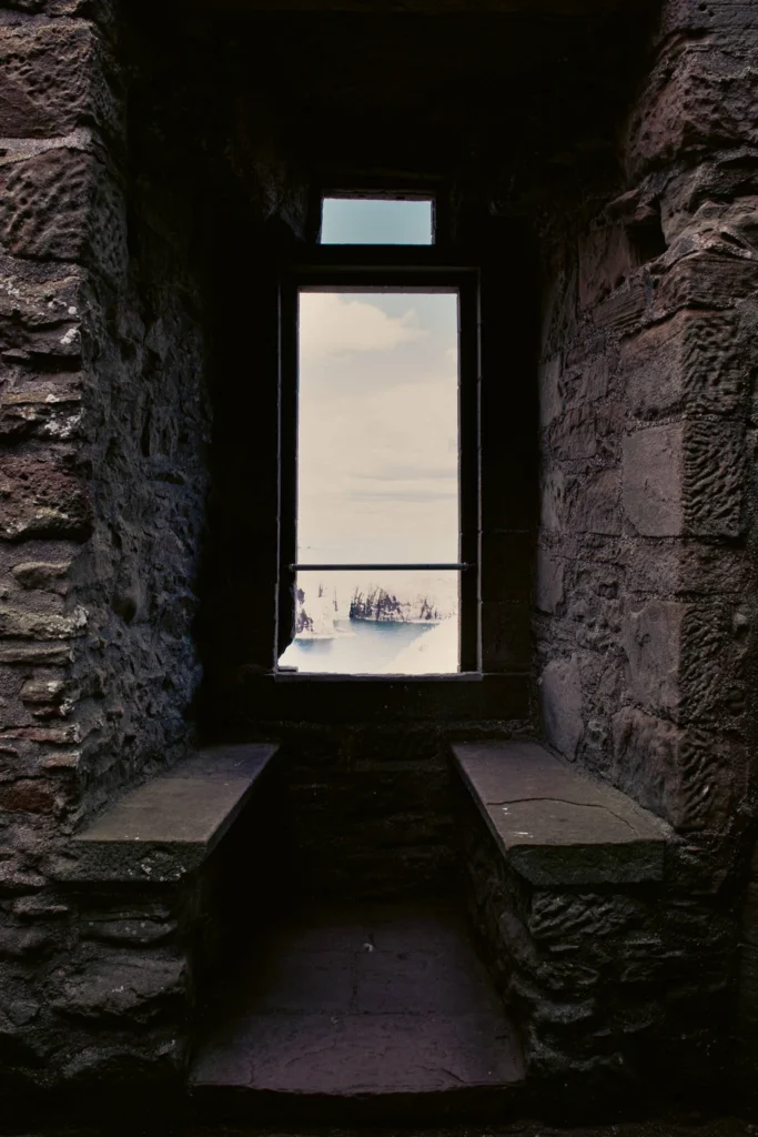 View from a stone window of Dunnottar Castle overlooking the cliffs and the sea