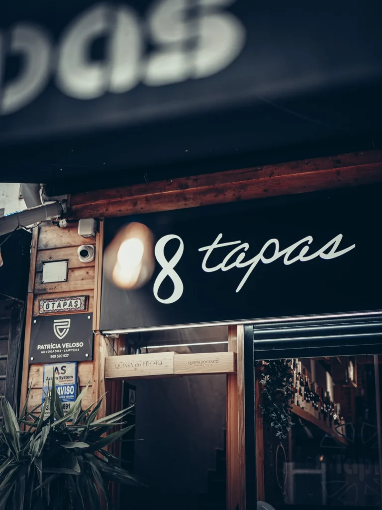 Fassade des Restaurants 8 Tapas in Faro, mit sichtbarem Schild und mit Pflanzen dekoriertem Eingang.