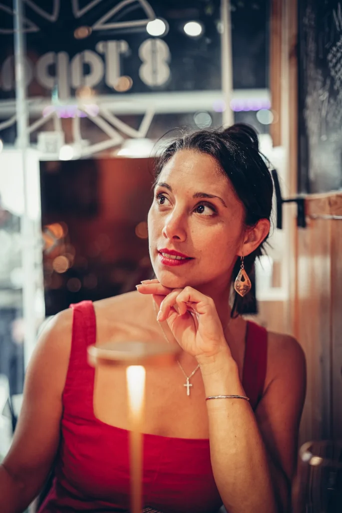 Caroline sitzt an einem Tisch im Restaurant 8 Tapas in Faro, warme Atmosphäre mit gedämpftem Licht.