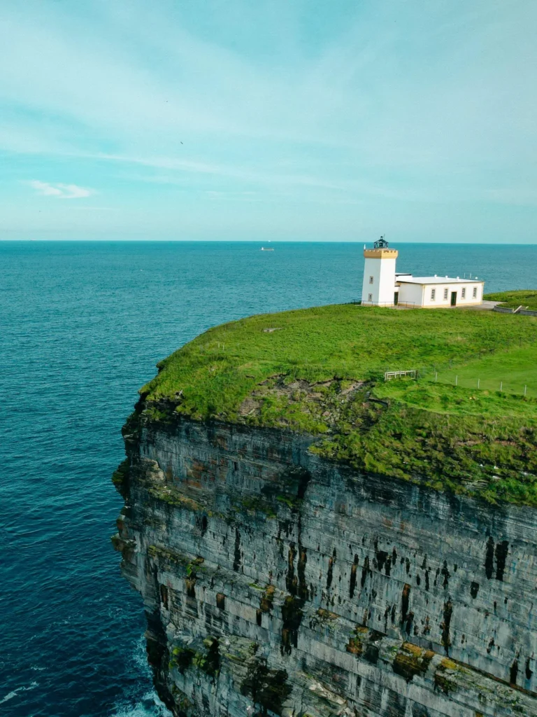 Duncansby Head white lighthouse isolated cliff sea Scotland