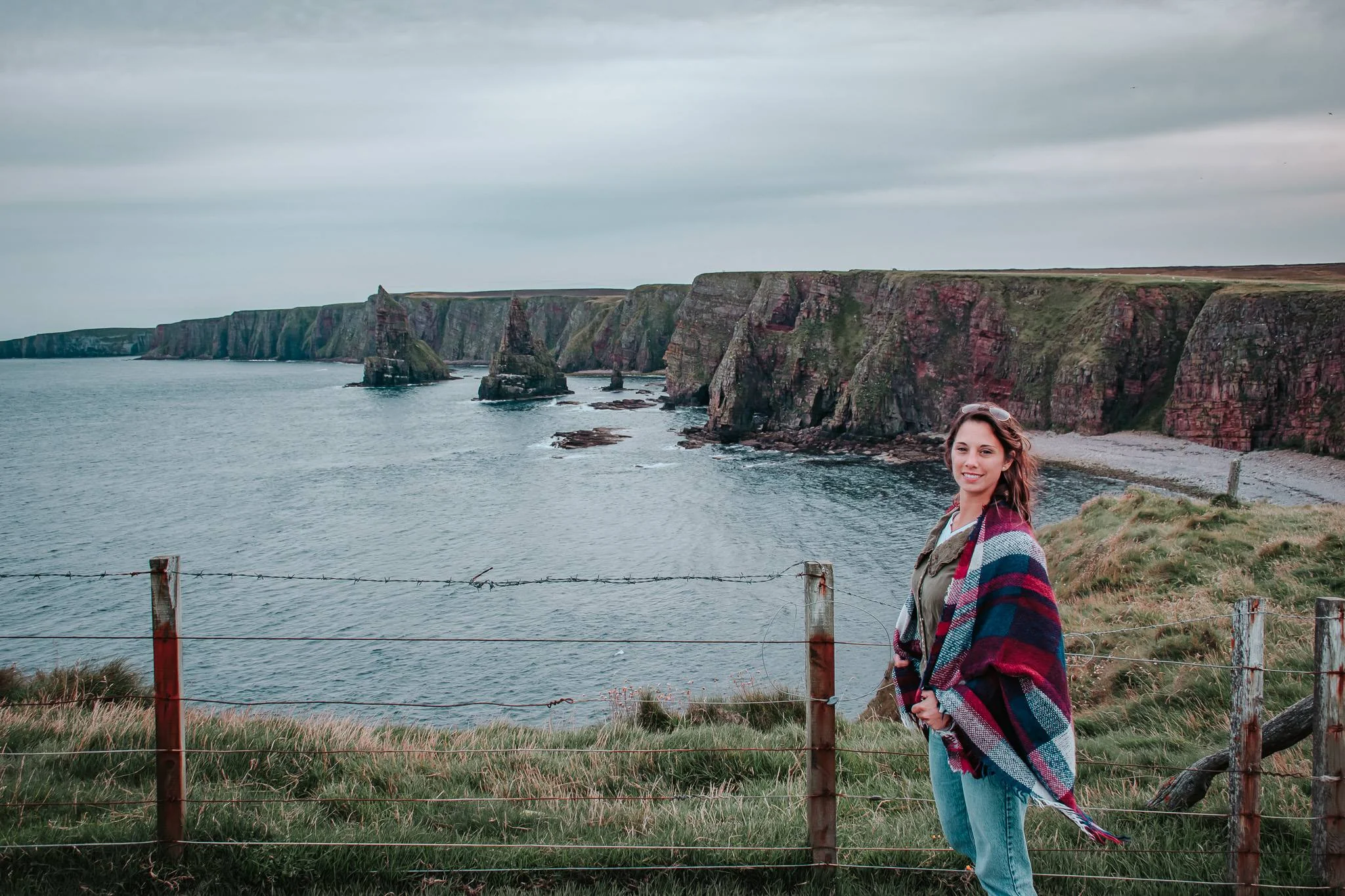 Caroline poses in front of the spectacular cliffs of John O'Groats