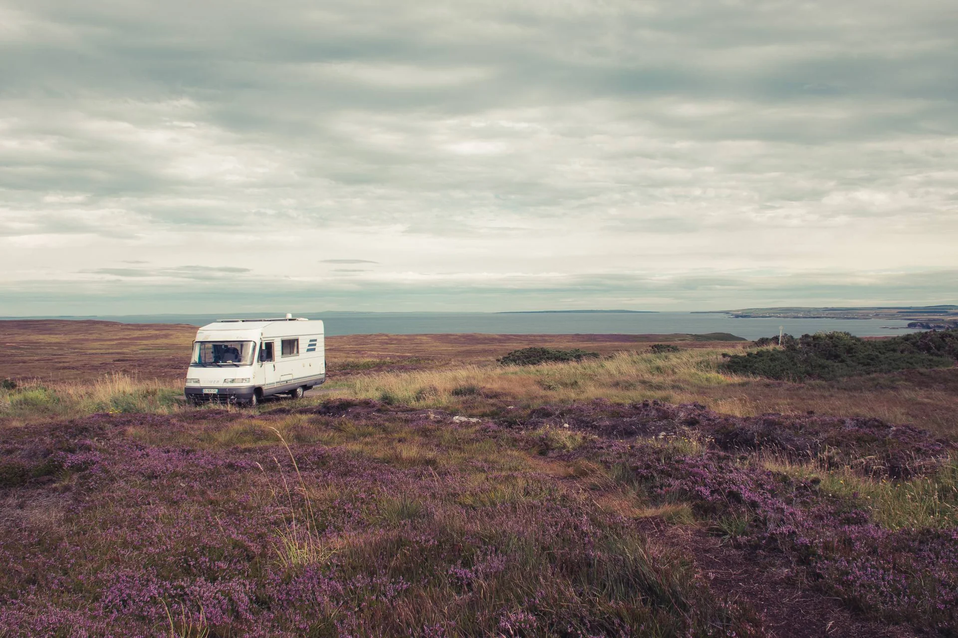 Isolated camper van parked on a Scottish moor in the north with a view of the sea
