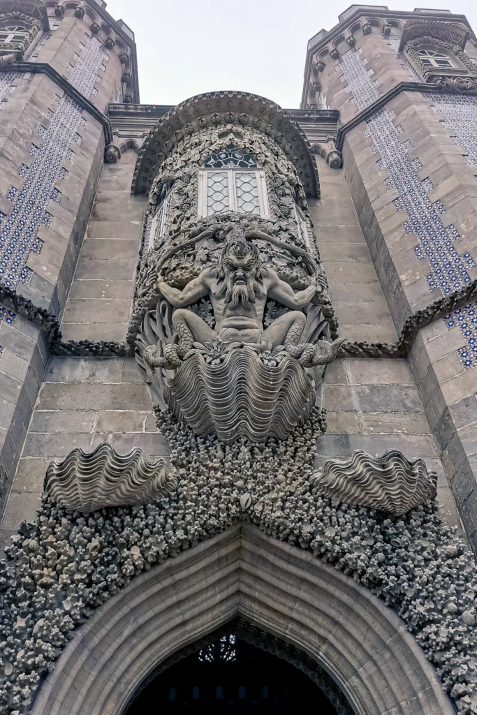 Ornate facade of the National Palace of Pena in Sintra, Portugal, featuring a mythological sculpture above an arched door, taken in winter 2022.