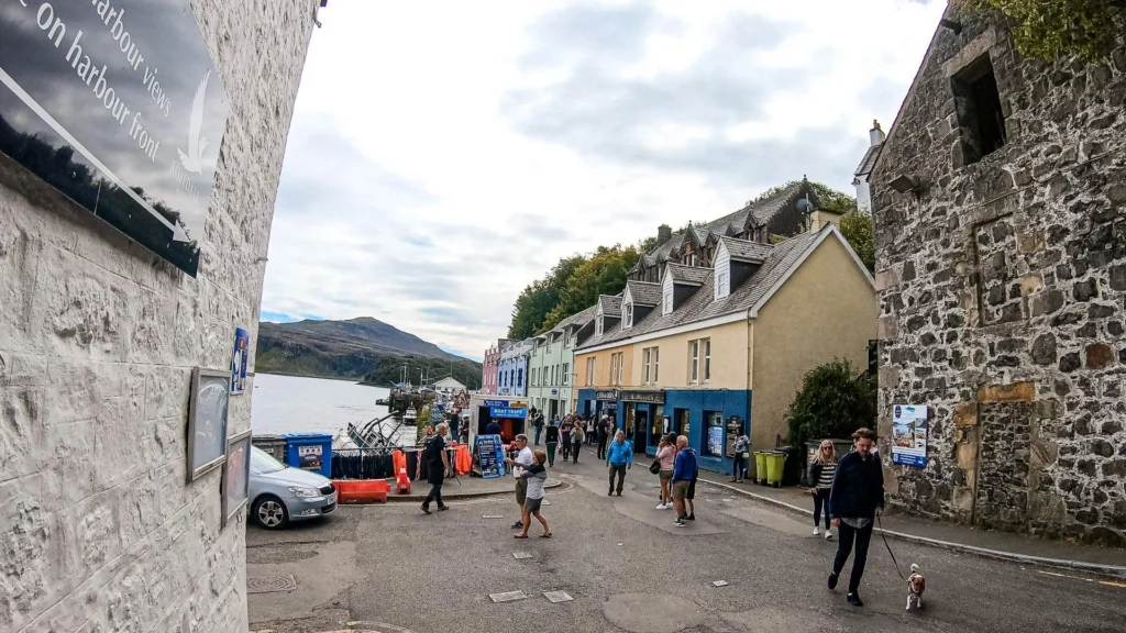 Busy street of Portree harbor with passersby Skye Island