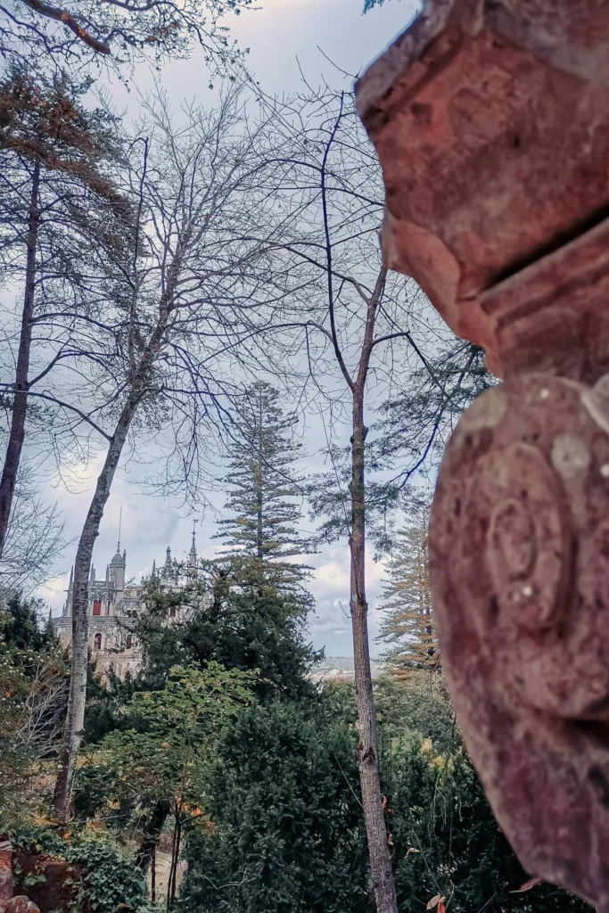 View of the Quinta da Regaleira palace through the trees, in a wooded park in Sintra, Portugal in March 2022.