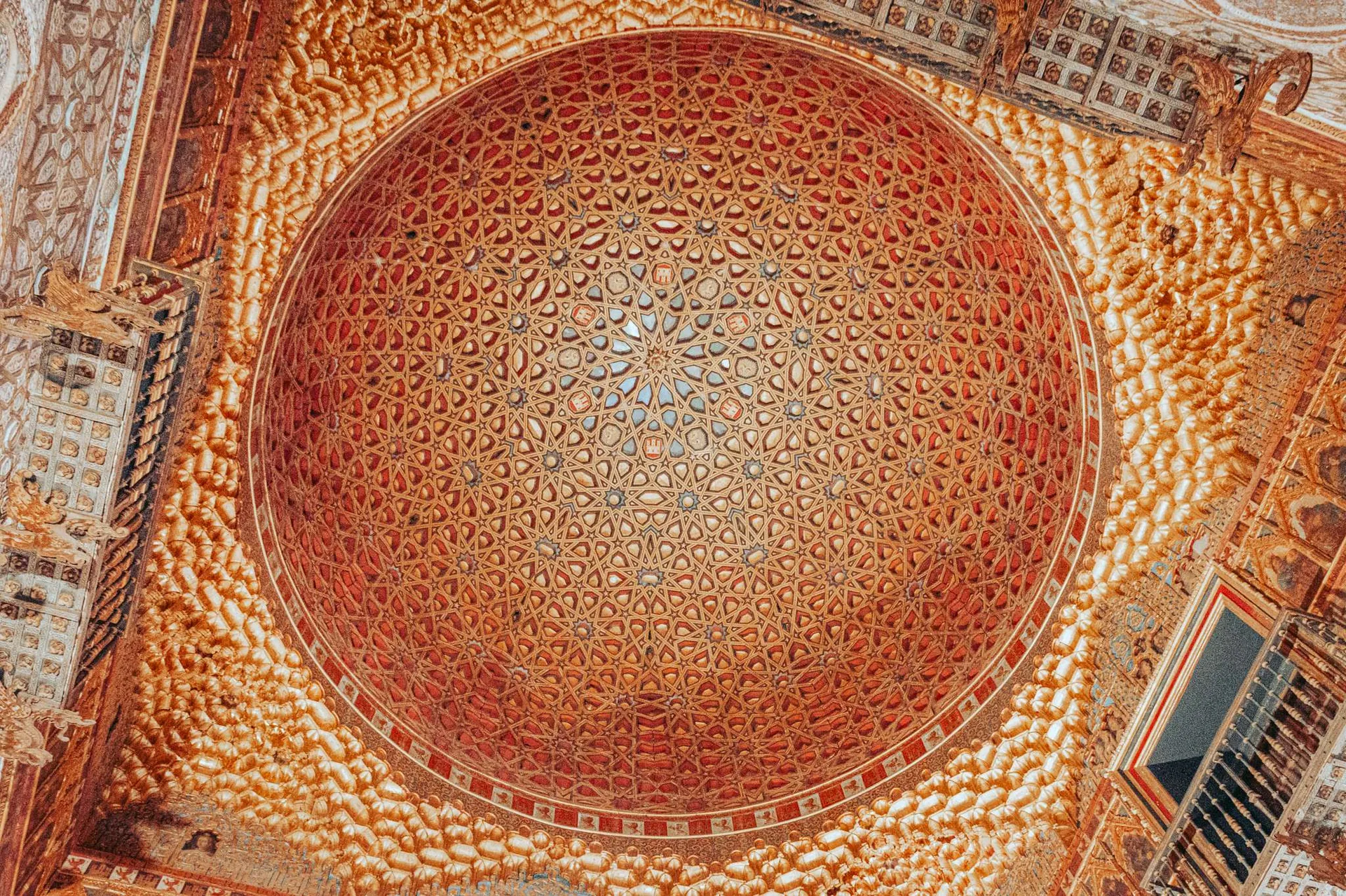 Plafond à coupole richement orné de motifs géométriques et dorés dans une salle du palais Alcazar de Séville, en Andalousie, photographié en octobre 2022.