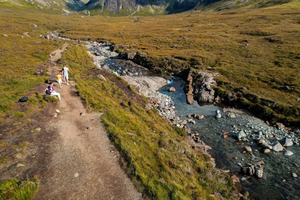 Hiking trail along the river of the Fairy Pools with walkers on the Isle of Skye