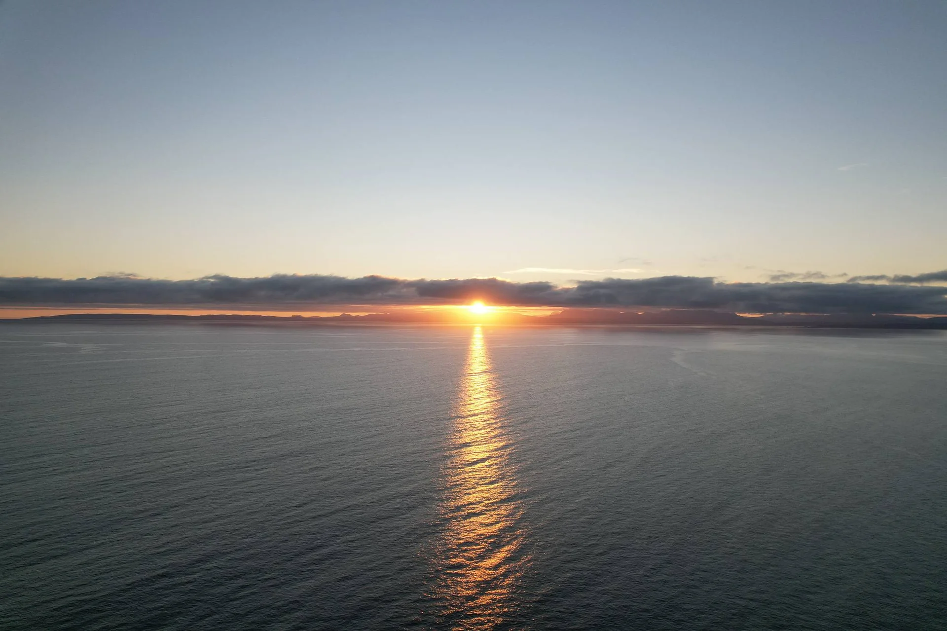 Sunset over the sea off the Isle of Skye with a clear horizon and low clouds