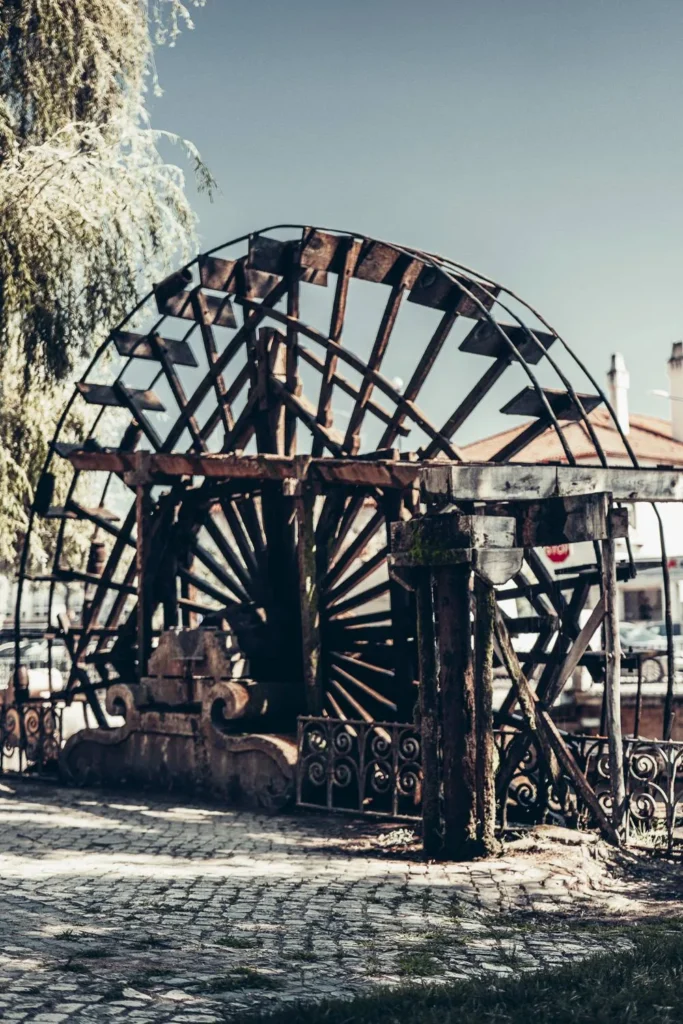 Grande roue à eau ancienne située dans le centre historique de Tomar, Portugal, photographiée en été sous un ciel clair.