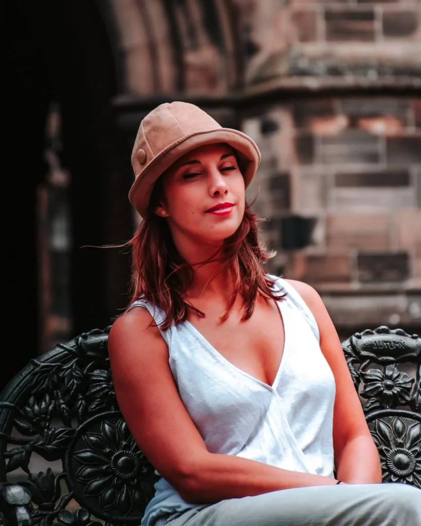 Caroline sitting on an ornate bench in front of a gothic facade