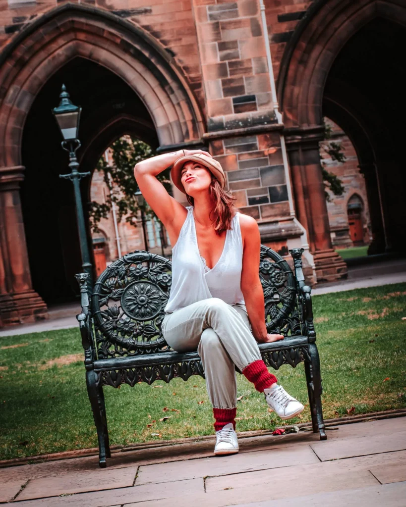 Caroline sitting on a wrought iron bench in the courtyard