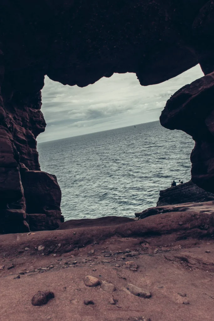 View of the North Sea through a natural red rock arch in Arbroath