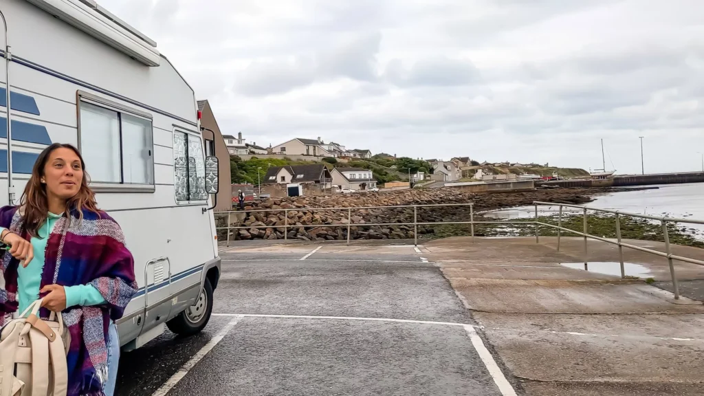 Caroline in front of a camper van parked near the port of Wick in Scotland