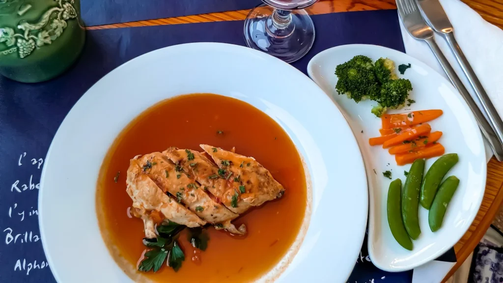 Plate of chicken supreme in sauce with steamed vegetables at the French restaurant in Wick