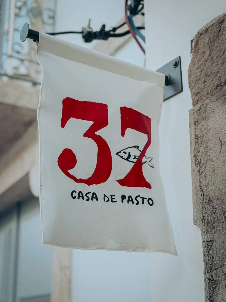 Restaurant sign 37 Casa de Pasto hanging on a wall in a street in Tavira, Algarve, Portugal.