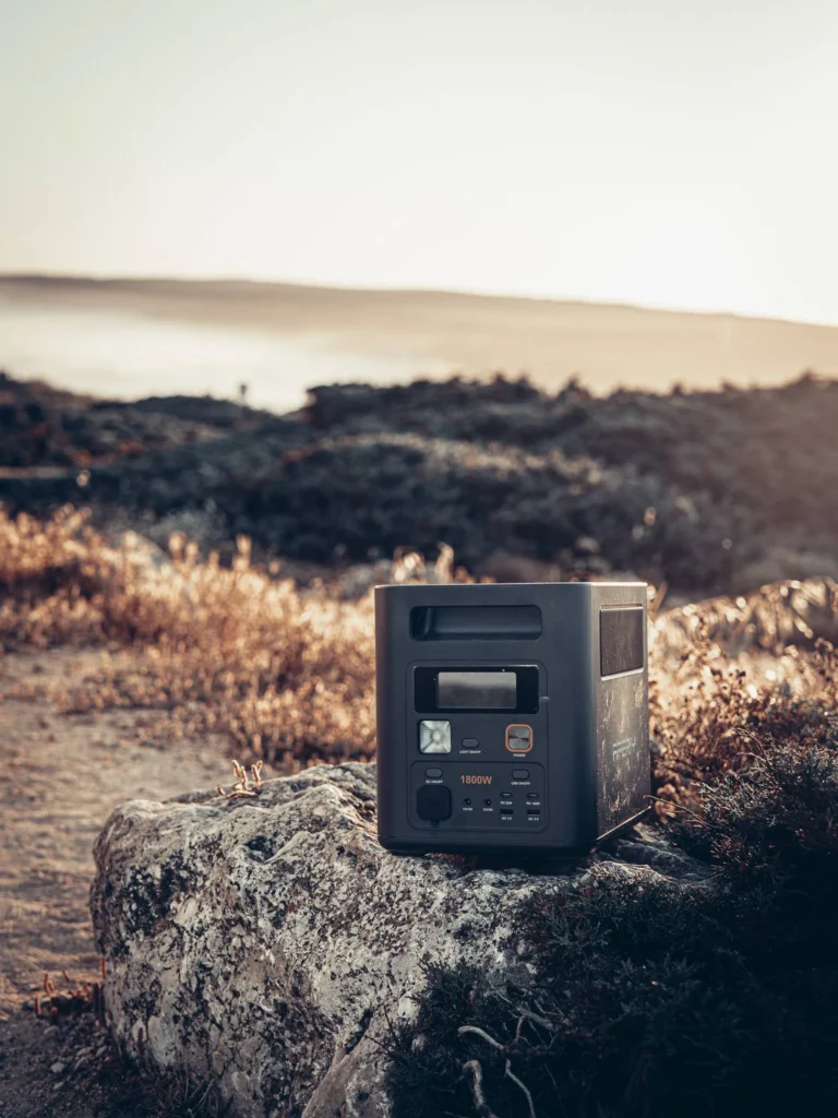 Aferiy Nomad 1800 power station placed on a rock at sunset on Bordeira beach in the Algarve
