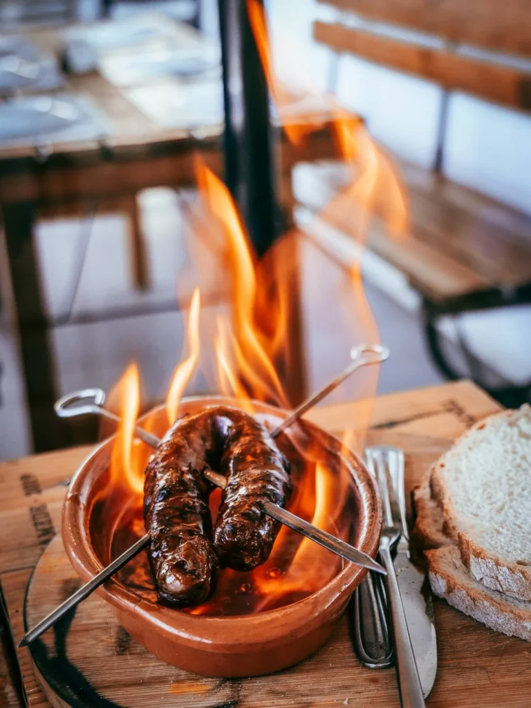 Flambeed chorizo served in a terracotta dish