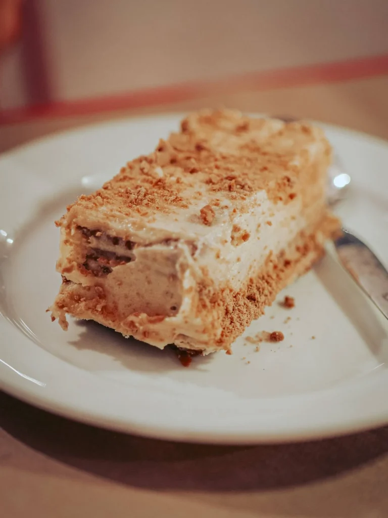 Creamy dessert slice made with biscuits, served on a white plate at Lumo restaurant in Tavira, Algarve, Portugal, in June.