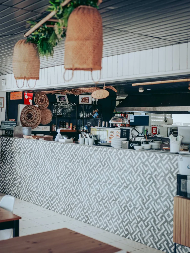 Counter of a beach restaurant in Tavira Island, Algarve, with wicker decor and geometric tiling, summer and relaxed atmosphere.