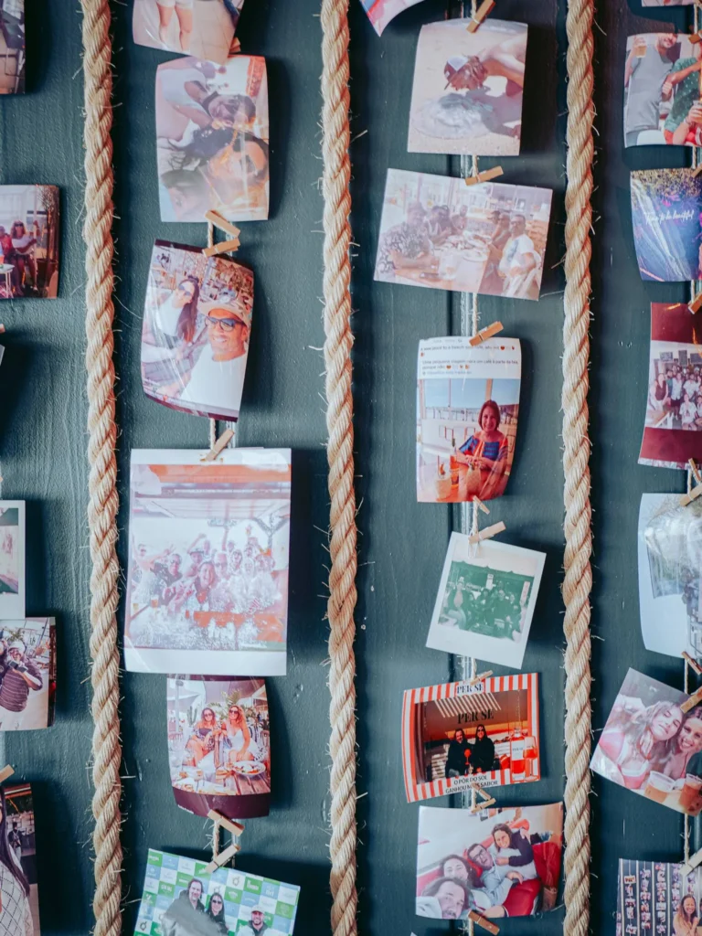 Several souvenir photos are hung on strings on a wall of the O Ferreira restaurant on the island of Tavira, illustrating moments of togetherness and travel.