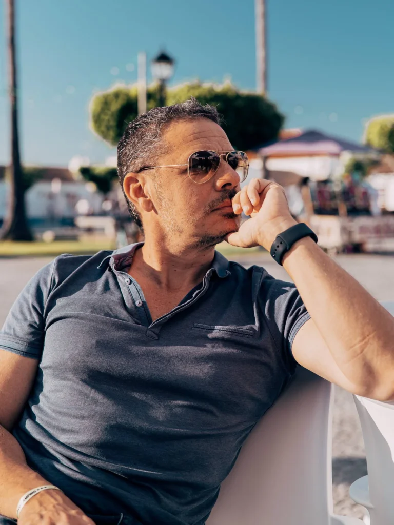 Xavier sitting on a terrace in Porto Covo, enjoying a sunny day in the summery atmosphere of Alentejo.