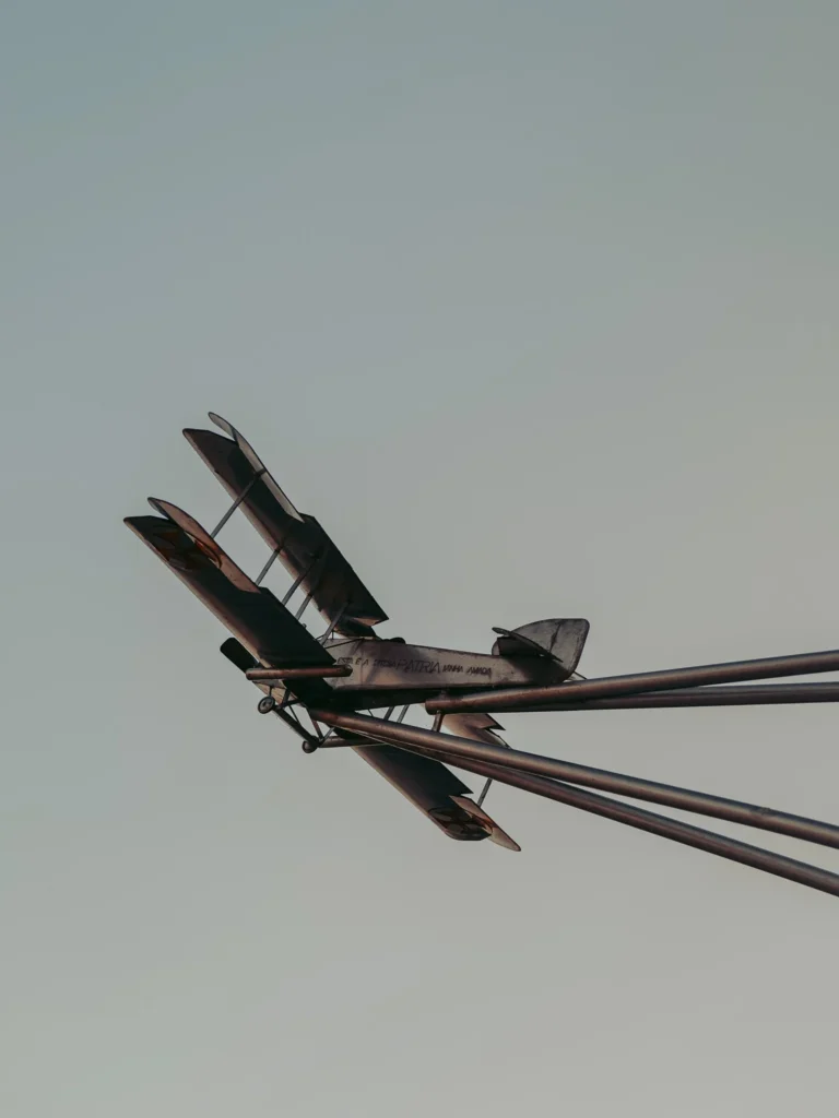 Monument to the seaplane "Pátria" in Vila Nova de Milfontes: metal sculpture of an old plane commemorating the first aerial crossing of the South Atlantic in 1922 by Portuguese aviators Gago Coutinho and Sacadura Cabral, under a clear sky in Alentejo.