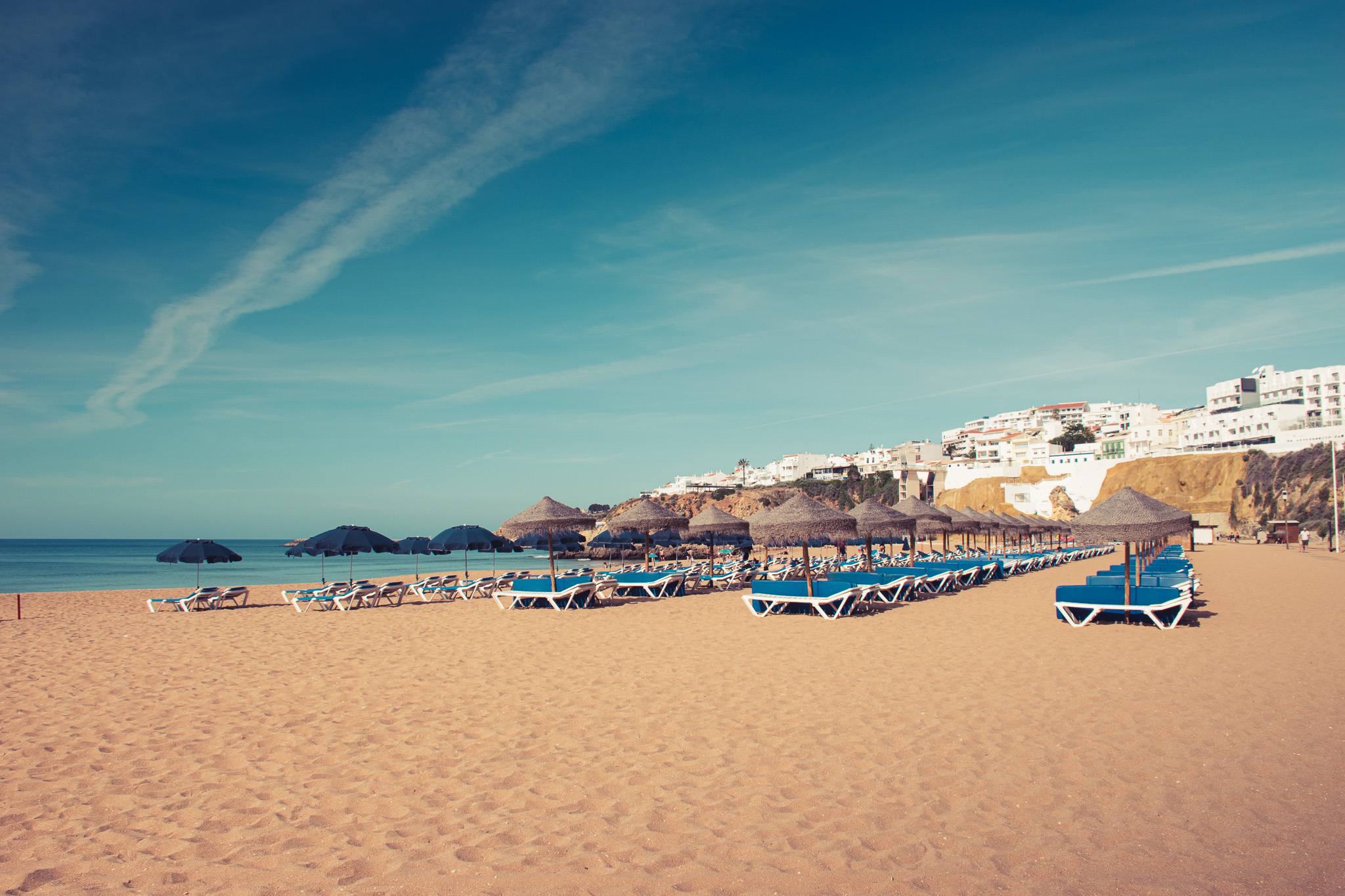 Albufeira beach with golden cliffs and straw umbrellas